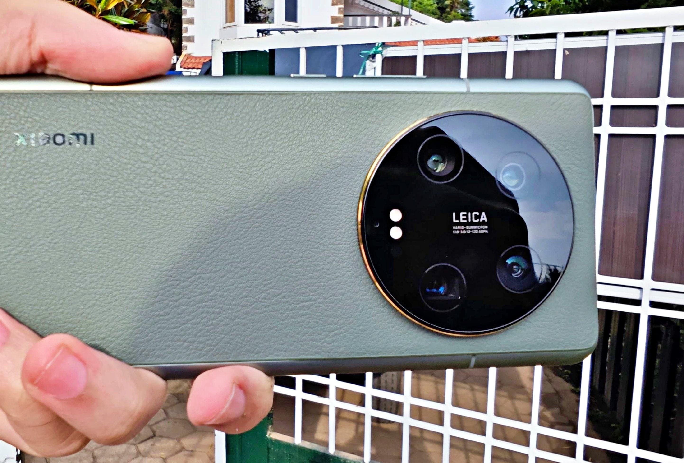 Смартфон Xiaomi с камерой Leica — крупный план блока камер с четырьмя объективами, золотистой окантовкой и логотипом Leica. Зелёный текстурированный корпус, логотип Xiaomi.